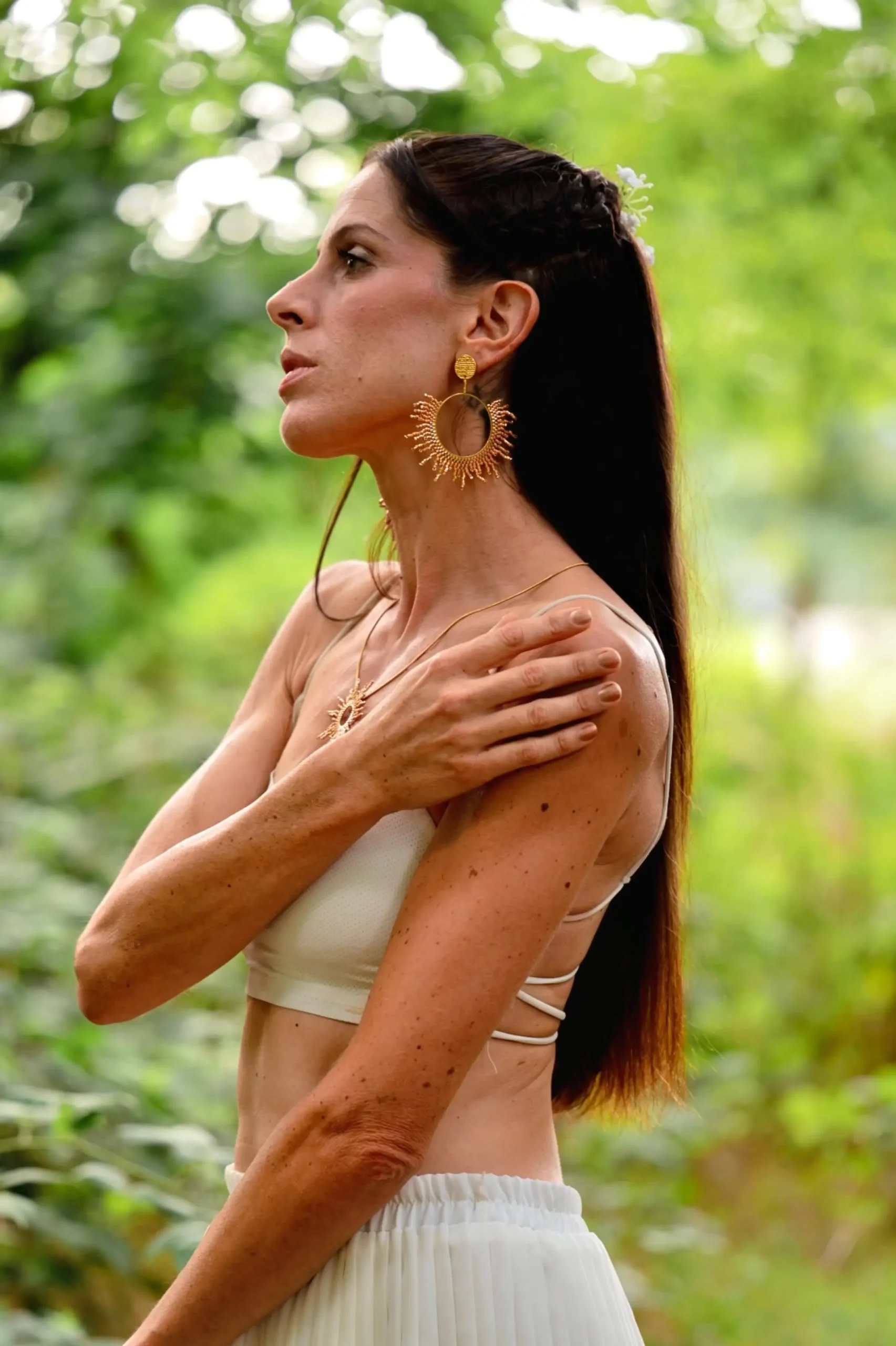 Femme portant les boucles Apollisia Solaris Valdyria en plan large, bijou artisanal en perles Miyuki fines plaqué or, fait main en Alsace.