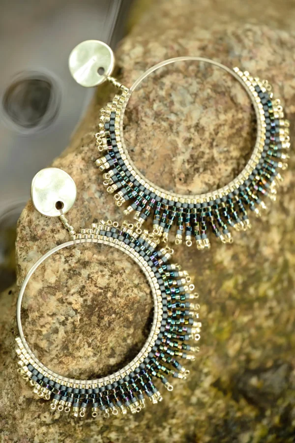 Boucles d’oreilles pendantes Artemesia Lunaris Valdyria en perles Miyuki irisées argent et bleu, posées sur une pierre minérale. Bijoux artisanaux faits main en Alsace, inspirés par la lune et la nature.