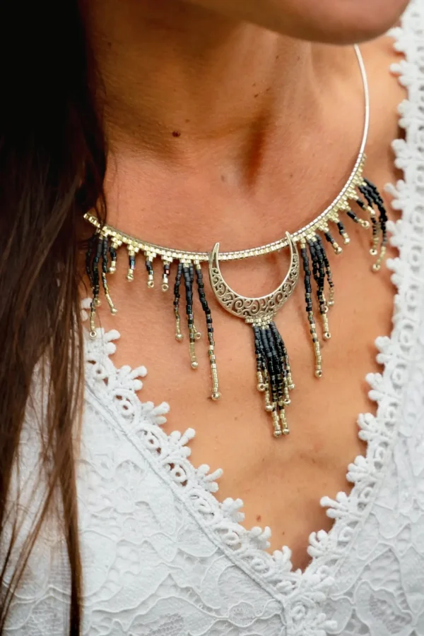 Collier Majestueux Artemesia Lunaris Valdyria porté par une femme, gros plan poitrine, bijou artisanal en perles Miyuki noir, or et argent.