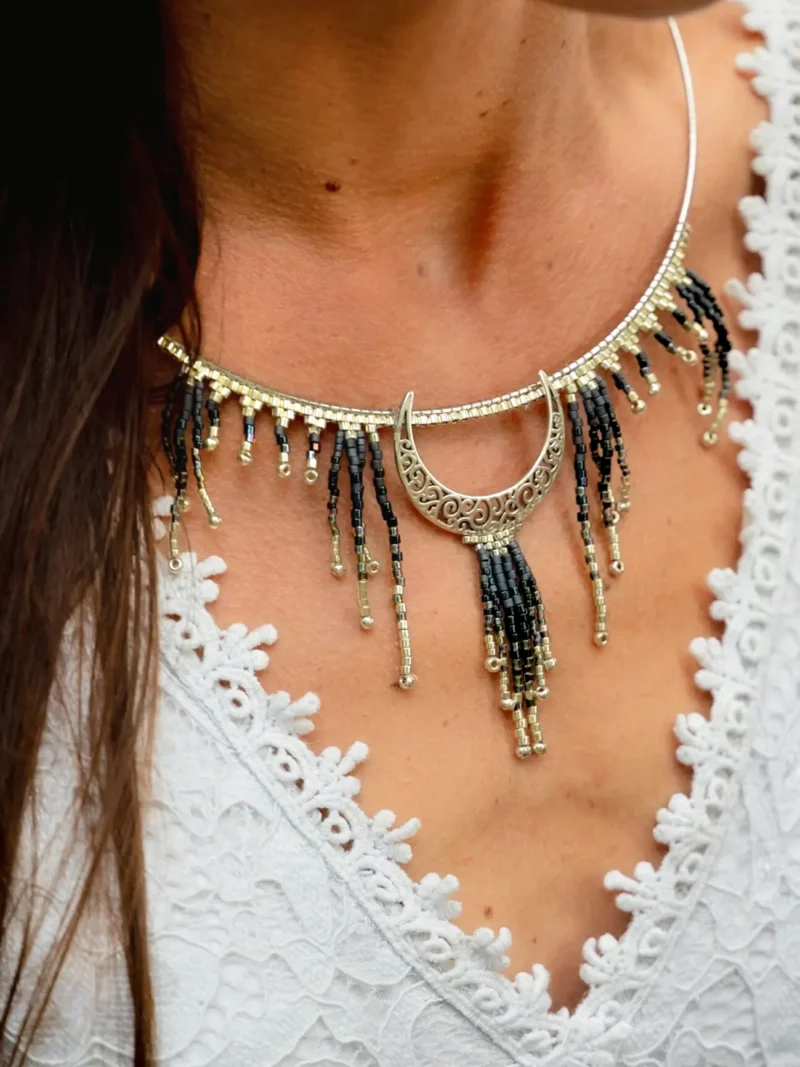 boutique-valdyria-artemesia-lunaris-collier-majestueux-gros-plan-poitrine-1 Collier Majestueux Artemesia Lunaris Valdyria porté par une femme, gros plan poitrine, bijou artisanal en perles Miyuki noir, or et argent.