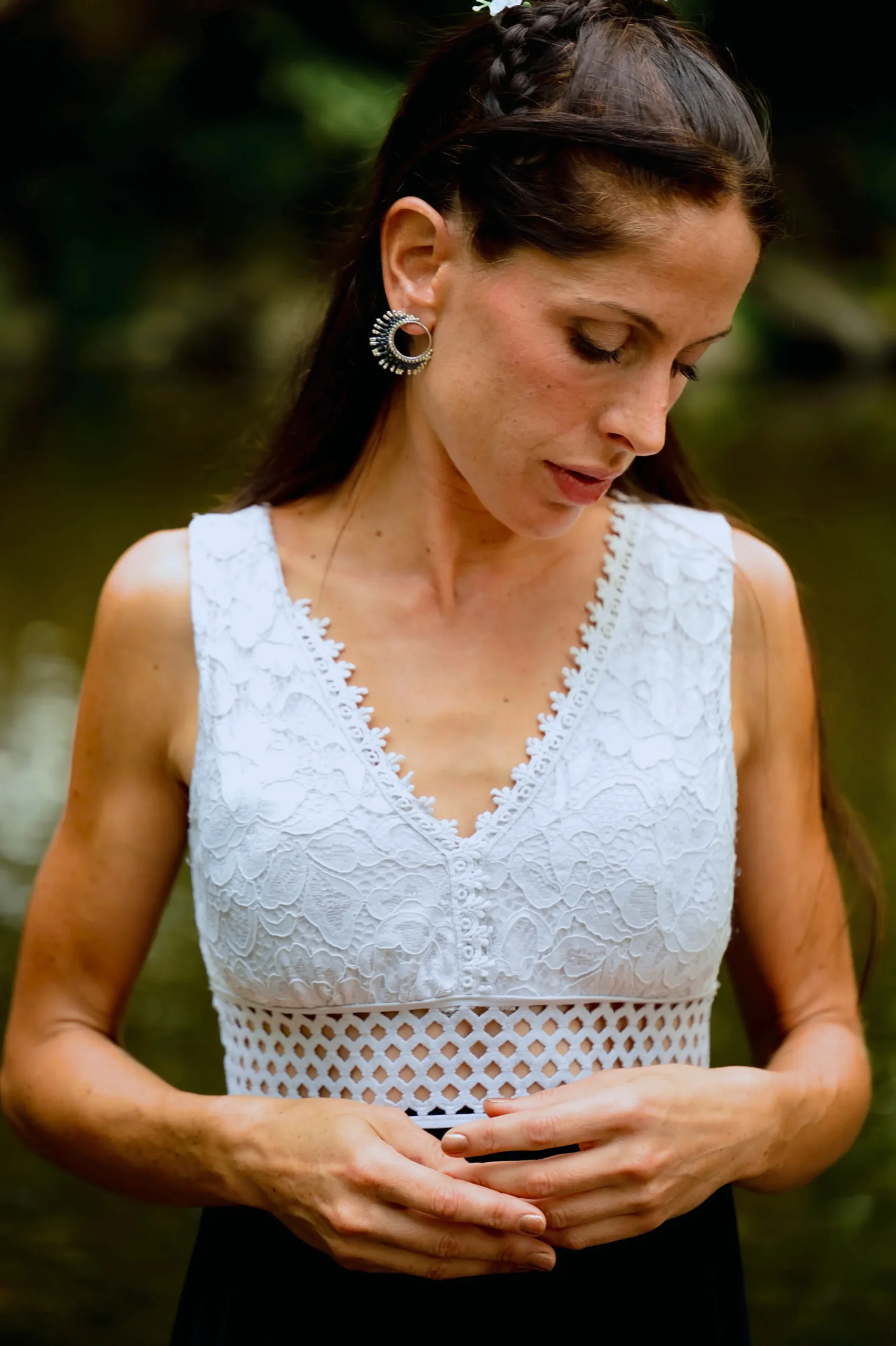 Femme regard baissé portant les petites boucles Artemesia Lunaris Valdyria en perles Miyuki argent et bleu. Bijou artisanal fait main.