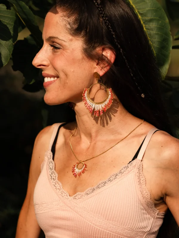 boutique-valdyria-mira-aurora-boucles-oreille-pendantes-profil-gauche Femme de profil gauche portant les boucles Mira Aurora Valdyria en perles Miyuki rose clair et rose foncé. Bijou artisanal fait main, talisman écoresponsable.