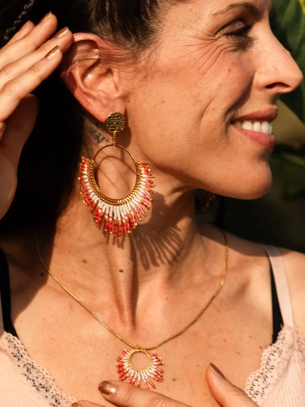 boutique-valdyria-mira-aurora-boucles-oreille-pendantes-gros-plan-sourire Femme souriante portant les boucles Mira Aurora Valdyria en perles Miyuki rose clair et rose foncé. Bijou artisanal fait main, talisman écoresponsable.