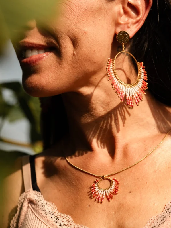 boutique-valdyria-mira-aurora-boucles-oreille-pendantes-portrait-souriant Femme souriante portant les boucles Mira Aurora Valdyria en perles Miyuki rose clair et rose foncé, avec collier assorti. Bijou artisanal fait main, talisman made in France.