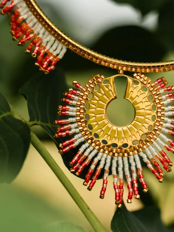 Collier Majestueux Mira Aurora Valdyria en perles Miyuki rose clair et rose foncé avec monture dorée, gros plan suspendu à des feuilles. Bijou artisanal fait main en Alsace, talisman écoresponsable.