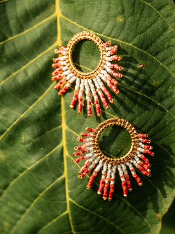Duo de petites boucles Mira Aurora Valdyria, perles Miyuki rose clair et foncé, monture dorée, disposées côte à côte sur une feuille verte. Bijoux artisanaux faits main en Alsace, symboles solaires.