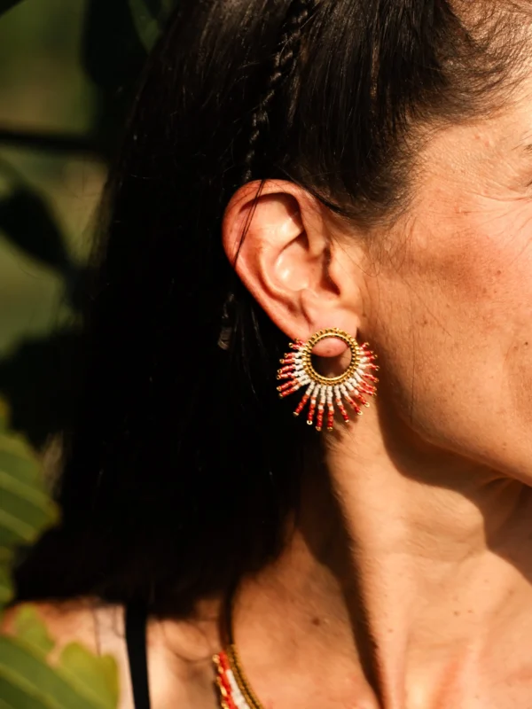 Femme de profil portant une petite boucle Mira Aurora Valdyria en perles Miyuki rose clair et foncé, monture dorée. Bijou artisanal poétique, slow jewelry made in France.