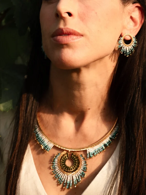 Collier Majestueux Mira Calypsa Valdyria, cercle doré orné de perles Miyuki turquoise et vert d’eau, gros plan sur la peau. Bijou artisanal alsacien, mystique et raffiné.