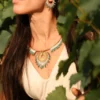 Collier Majestueux Mira Calypsa Valdyria porté au cou, perles Miyuki turquoise et vert d’eau, monture dorée, photographié dans le feuillage. Bijou artisanal made in France, inspiré par la nature.