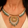 Collier Majestueux Mira Calypsa Valdyria, pendentif doré orné de perles Miyuki turquoise et blanches, porté au cou. Bijou artisanal fait main en Alsace, création durable et poétique.