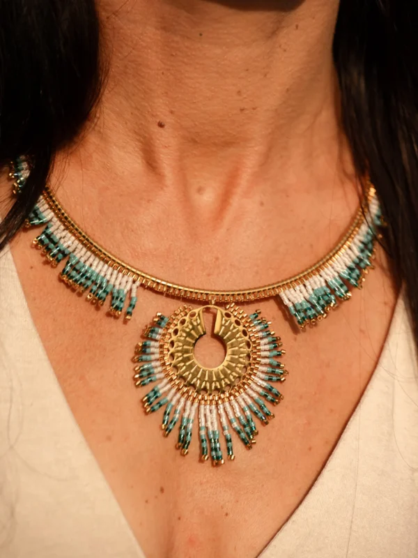 Collier Majestueux Mira Calypsa Valdyria, pendentif doré orné de perles Miyuki turquoise et blanches, porté au cou. Bijou artisanal fait main en Alsace, création durable et poétique.