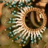 Petites boucles Mira Calypsa Valdyria, tissées de perles Miyuki turquoise et blanches, monture dorée, posées sur des grappes de raisin. Bijoux artisanaux français, poétiques et écoresponsables.