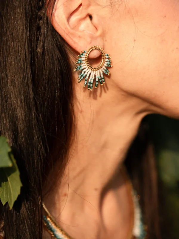 Femme portant la parure Mira Calypsa Valdyria, collier majestueux et petites boucles assorties, perles Miyuki turquoise et blanches. Bijoux artisanaux français, durables et poétiques.