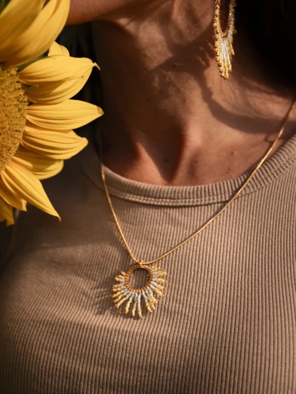 Gros plan du collier Mira Helia sautoir en perles Miyuki dorées et blanches, porté au niveau du cou. Bijou artisanal français, fait main en Alsace, création durable et écoresponsable.