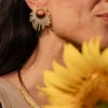 boutique-valdyria-mira-helia-petite-boucle-oreille-portrait-tournesol Petite boucle d’oreille Mira Helia en perles Miyuki dorées et blanches, portée avec un tournesol en avant-plan. Bijou artisanal français, fait main en Alsace, création durable et solaire.