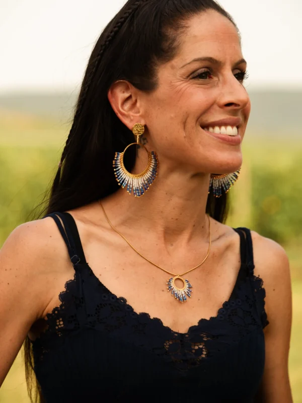 Boucles d’oreilles pendantes Mira Obscura en perles Miyuki bleu nuit et dorées, portées avec collier assorti. Bijoux artisanaux français, faits main en Alsace, créations durables et inspirées des astres.