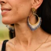 Boucles d’oreilles pendantes Mira Obscura en perles Miyuki bleu nuit, blanches et dorées, portées avec collier assorti. Bijoux artisanaux français, faits main en Alsace, créations éthiques et durables.