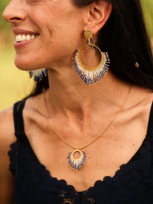 Boucles d’oreilles pendantes Mira Obscura en perles Miyuki bleues et dorées, portées avec le collier assorti. Bijoux artisanaux français, faits main en Alsace, créations écoresponsables et lumineuses.