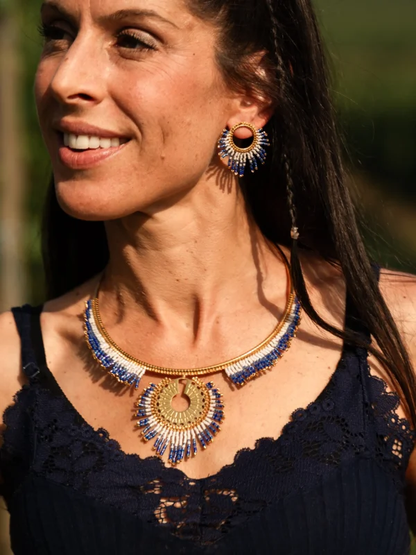 Collier majestueux Mira Obscura en perles Miyuki bleu nuit, dorées et blanches, porté avec boucles assorties. Bijoux artisanaux français, faits main en Alsace, créations durables et poétiques.