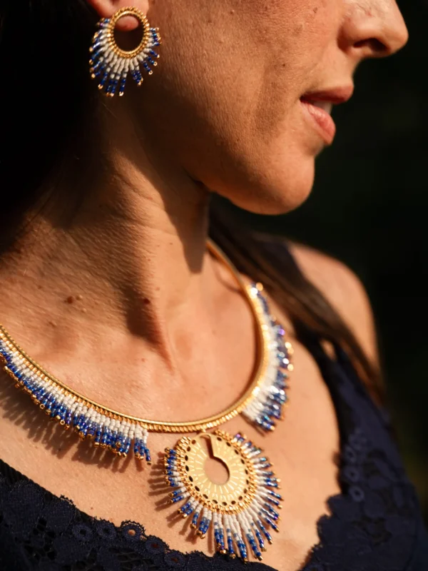 Collier majestueux Mira Obscura en perles Miyuki bleu nuit, dorées et blanches, porté en portrait de profil avec robe bleu marine. Bijou artisanal français, fait main en Alsace, création durable et poétique.