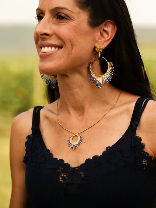 Collier sautoir Mira Obscura en perles Miyuki bleues et dorées, porté en portrait doux avec sourire. Bijou artisanal français, fait main en Alsace, création durable et inspirée des étoiles.