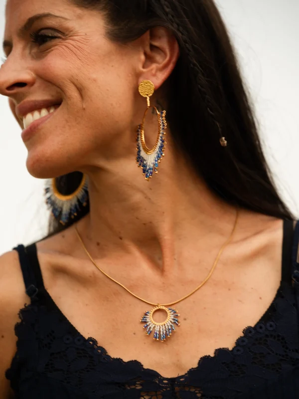 Collier sautoir Mira Obscura en perles Miyuki bleues, blanches et dorées, porté en portrait souriant avec boucle assortie. Bijou artisanal français, fait main en Alsace, création durable et inspirée du cosmos.