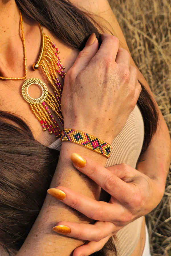 Bracelet Amaziga Rubra porté au poignet avec perles roses et détails dorés artisanaux