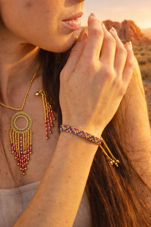 Bracelet fin Amaziga Rubra et geste du corps Bracelet fin Amaziga Rubra porté au poignet avec perles roses et détails artisanaux