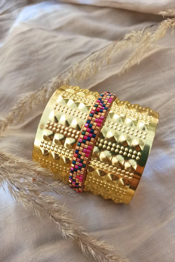 Bracelet fin Amaziga Rubra et talisman vivant Bracelet fin Amaziga Rubra posé avec perles roses et détails dorés artisanaux