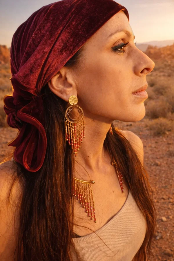 Grandes boucles d’oreilles Amaziga Rubra et héritage Grandes boucles d’oreilles Amaziga Rubra portées avec collier assorti dans un environnement naturel