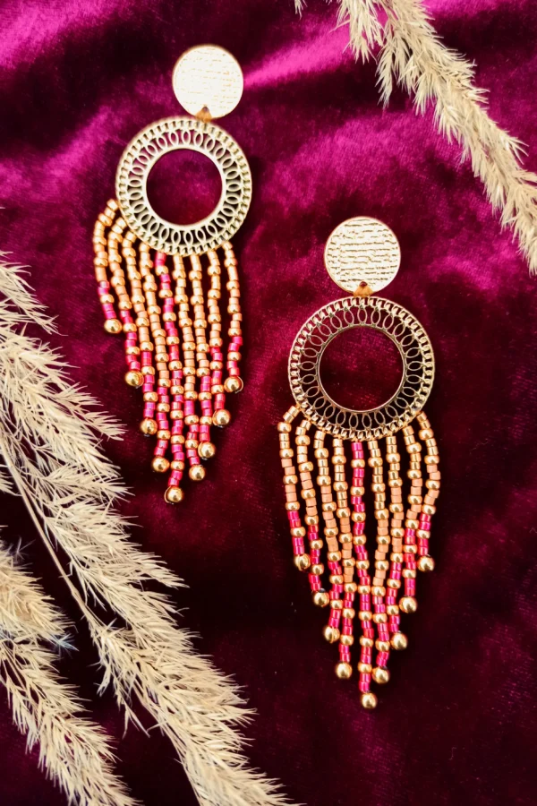 Grandes boucles d’oreilles Amaziga Rubra et féminité incarnée Grandes boucles d’oreilles Amaziga Rubra en perles roses avec structure dorée artisanale