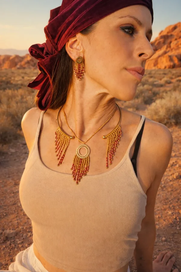 Collier majestueux Amaziga Rubra et parure de vie Collier majestueux Amaziga Rubra porté avec perles roses et éléments dorés sur peau