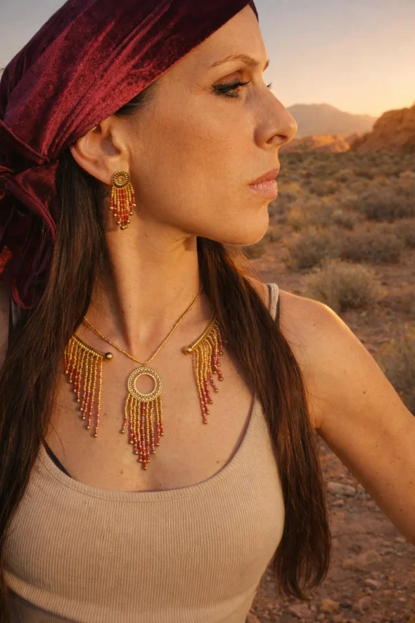 Collier majestueux Amaziga Rubra et héritage féminin Collier majestueux Amaziga Rubra porté avec boucles d’oreilles assorties dans un paysage naturel