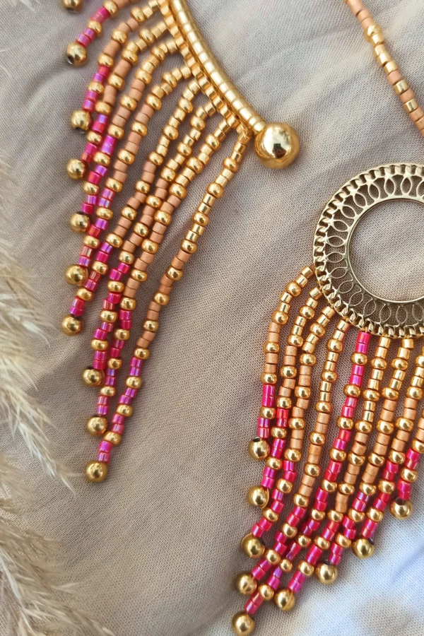 Collier majestueux Amaziga Rubra et détail artisanal Détail collier majestueux Amaziga Rubra avec franges de perles roses et éléments dorés