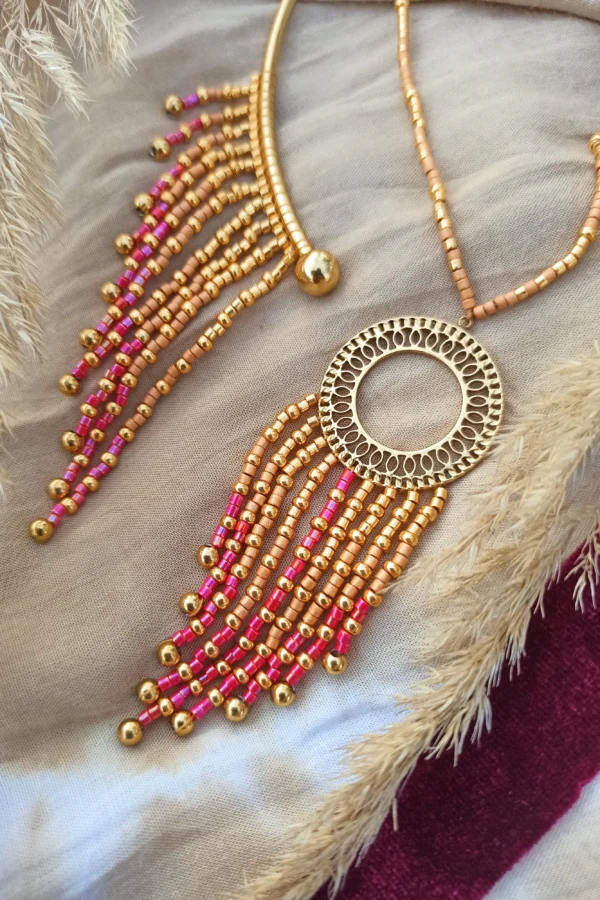 Collier majestueux Amaziga Rubra et talisman incarné Collier majestueux Amaziga Rubra posé avec perles roses et détails dorés artisanaux