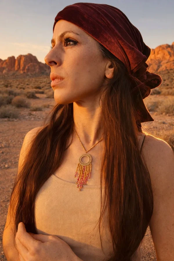 Femme portant un collier à pendentif Amaziga Rubra inspiré des traditions amazighes et de la terre