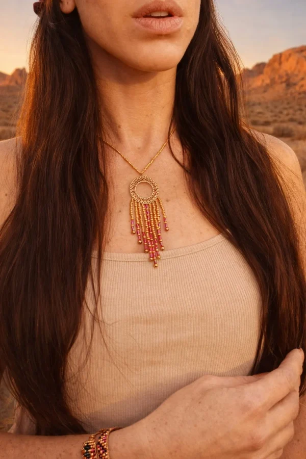 Détail d’un collier à pendentif Amaziga Rubra avec perles roses et motifs inspirés de la fertilité