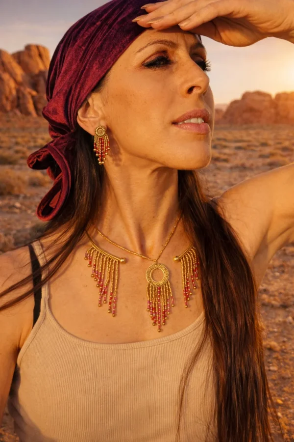 Petites boucles d’oreilles Amaziga Rubra et fertilité Petites boucles d’oreilles Amaziga Rubra portées en gros plan avec détails roses et dorés