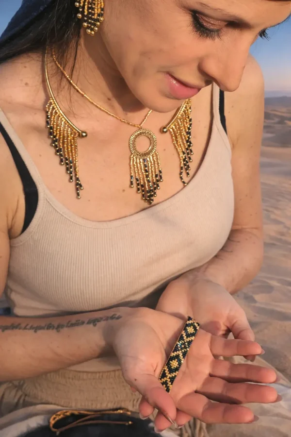 Bracelet bleu irisé Amaziga Sacra porté sur la peau dans un environnement désertique naturel