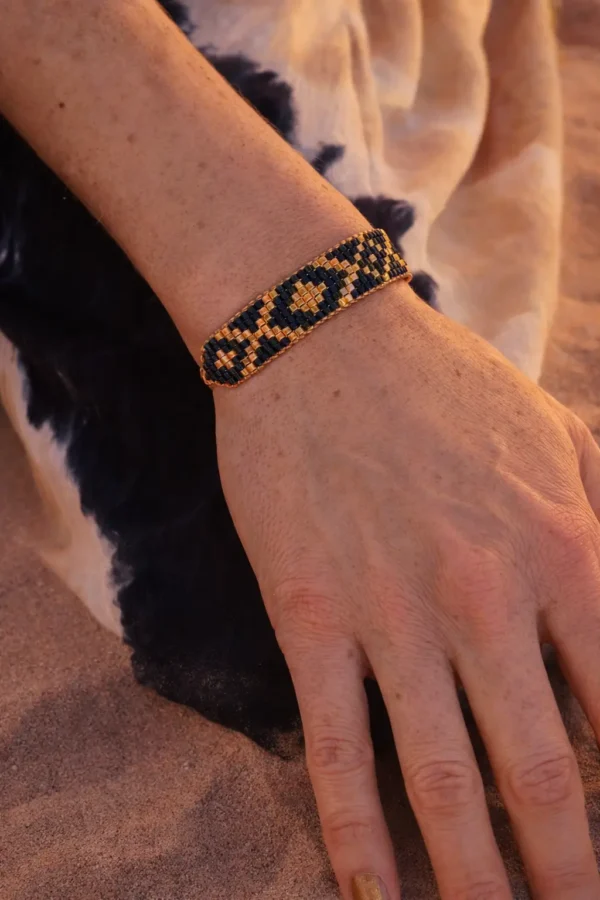 Bracelet bleu irisé Amaziga Sacra porté sur le poignet avec reflets bleus et détails dorés