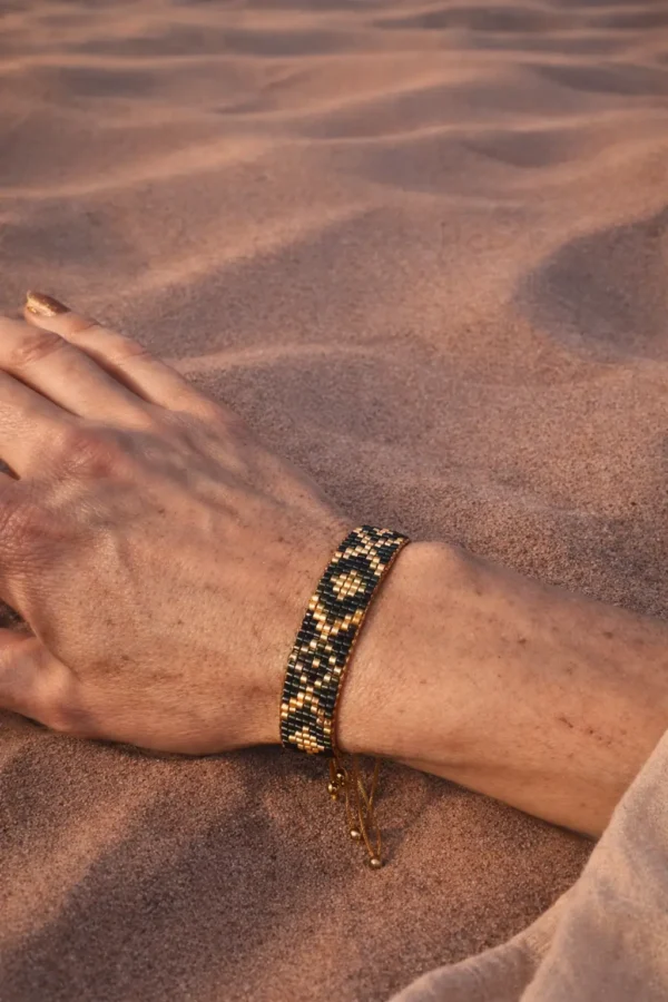 Bracelet bleu irisé Amaziga Sacra porté en mouvement avec reflets bleus et motifs artisanaux