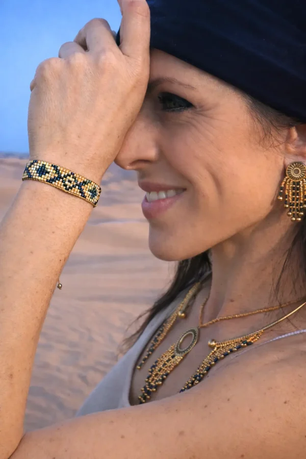 Bracelet bronze Amaziga Sacra porté sur le poignet avec perles bleues et structure dorée