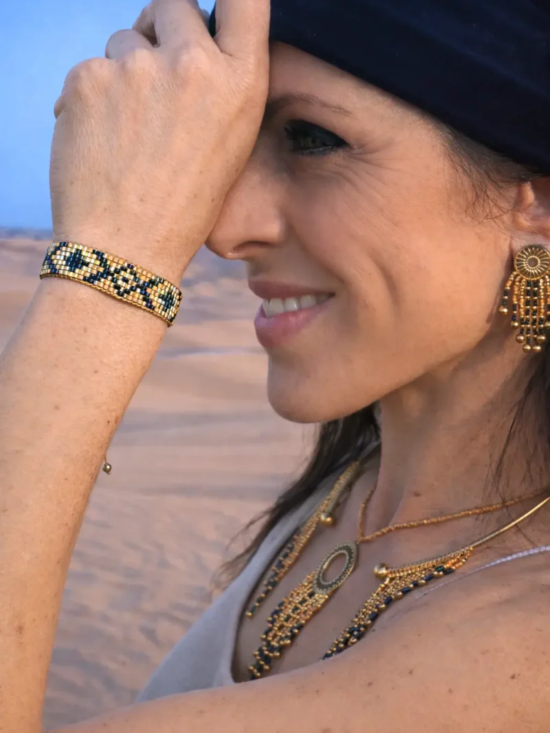 Bracelet bronze Amaziga Sacra porté sur le poignet avec perles bleues et structure dorée