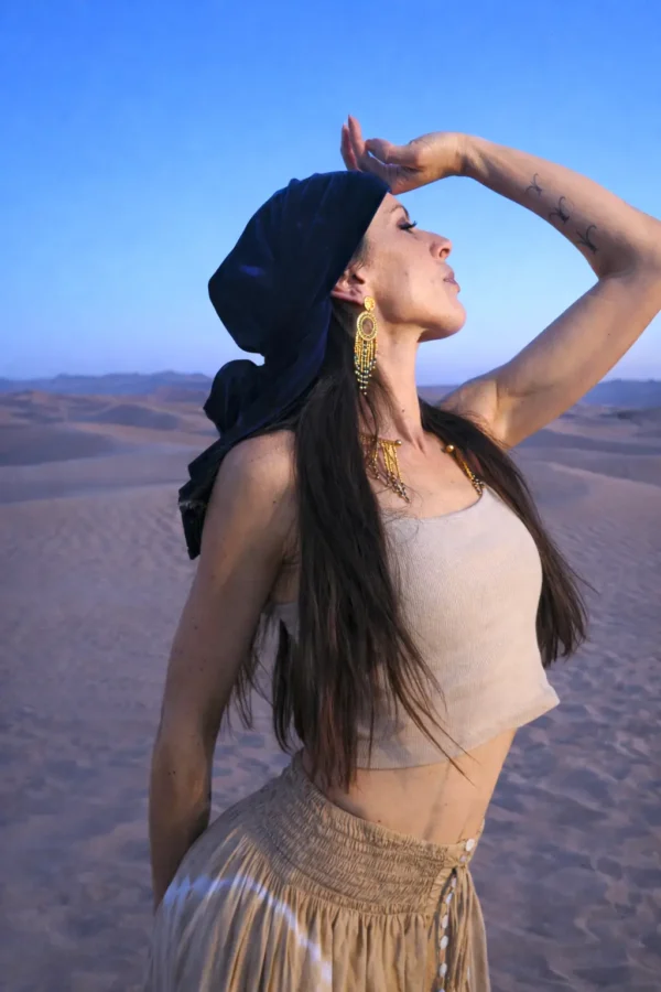 Grandes boucles d’oreilles Amaziga Sacra et protection céleste Grandes boucles d’oreilles Amaziga Sacra portées dans un désert sous ciel bleu profond inspiré du Sahara