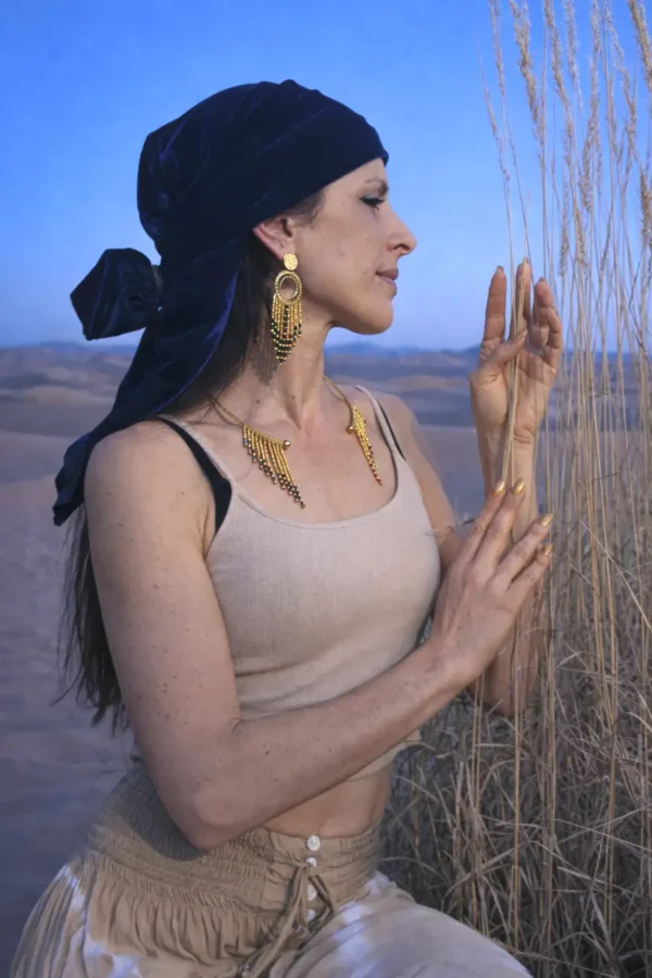 Grandes boucles d’oreilles Amaziga Sacra et connexion à l’invisible Grandes boucles d’oreilles Amaziga Sacra portées en gros plan avec perles bleues et éléments dorés