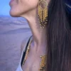 Grandes boucles d’oreilles Amaziga Sacra portées en mouvement avec franges et perles bleues Grandes boucles d’oreilles Amaziga Sacra portées en mouvement avec franges et perles bleues