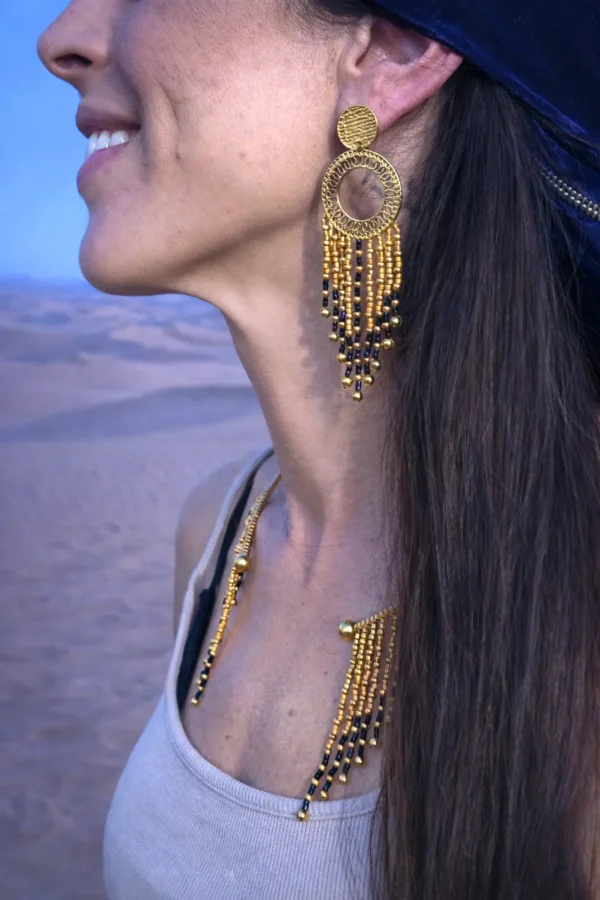 Grandes boucles d’oreilles Amaziga Sacra portées en mouvement avec franges et perles bleues Grandes boucles d’oreilles Amaziga Sacra portées en mouvement avec franges et perles bleues