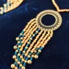Ce collier majestueux Amaziga Sacra révèle la richesse du travail artisanal et la puissance des symboles. Le cercle évoque la continuité et la protection, tandis que les perles bleues rappellent le ciel et l’infini. Inspiré des parures amazighes, ce bijou devient un talisman sacré, porteur de transmission et de mémoire.