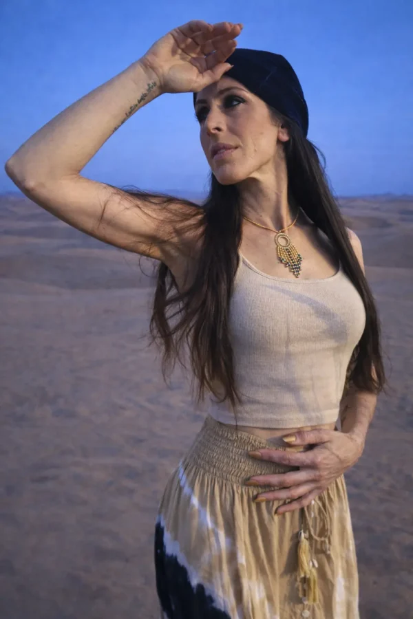 Collier à pendentif Amaziga Sacra porté dans un désert sous ciel bleu profond inspiré du Sahara Collier à pendentif Amaziga Sacra porté dans un désert sous ciel bleu profond inspiré du Sahara