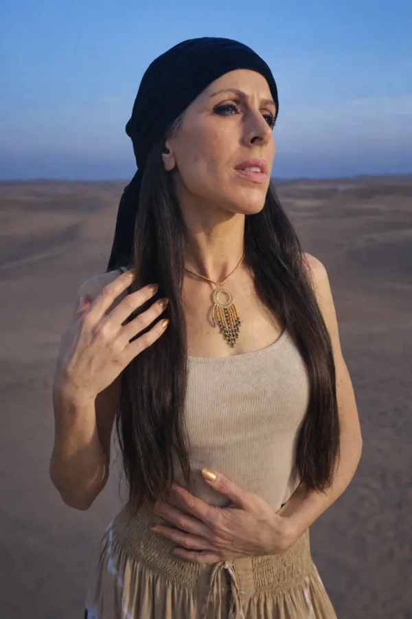 Collier à pendentif Amaziga Sacra et symbole protecteur Collier à pendentif Amaziga Sacra porté avec bijoux assortis dans un environnement désertique